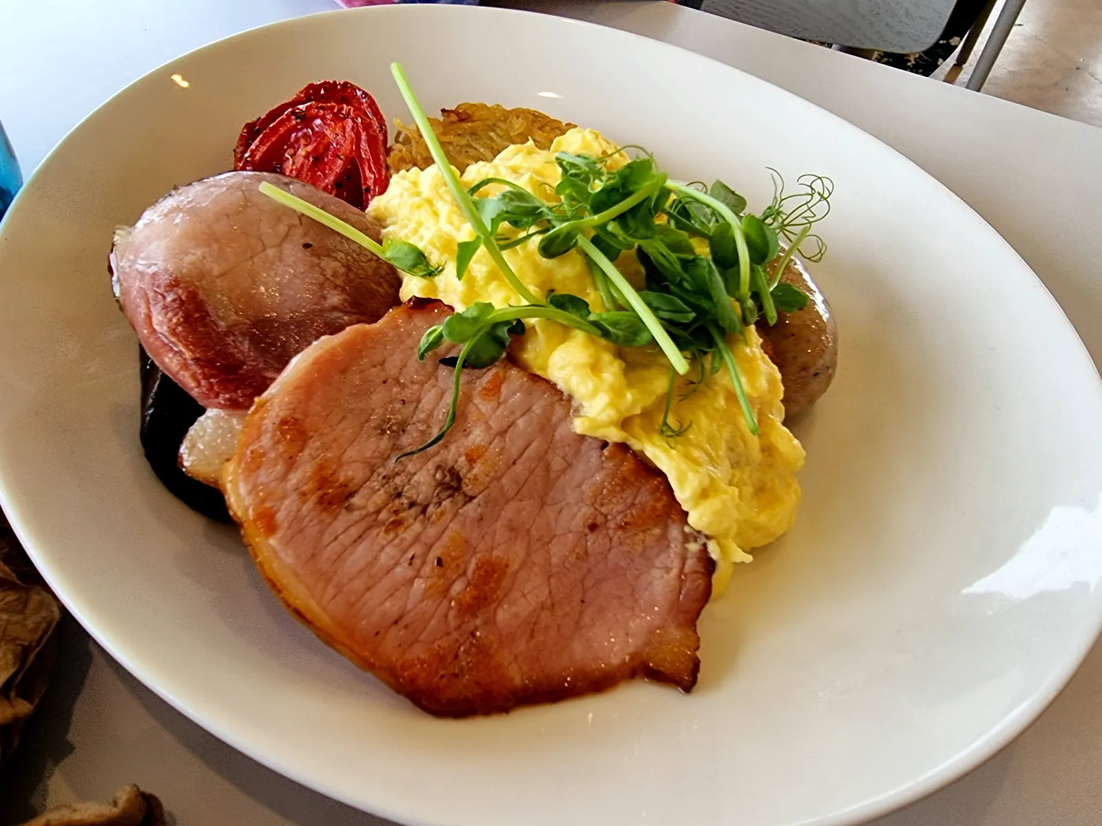 Cape Kitchen breakfast plate with ham, scrambled eggs, herbs, sausage and roasted tomato