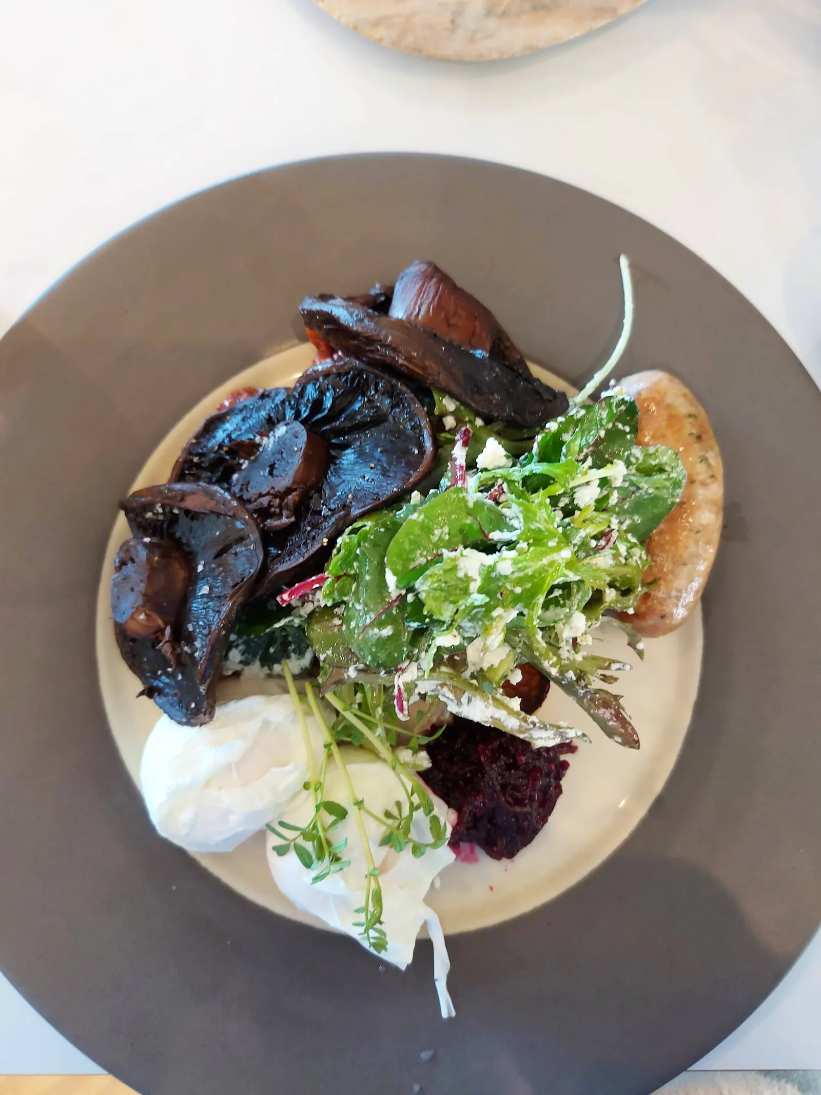 Vegetarian breakfast plate with mushrooms, poached egg, feta salad and beetroot puree